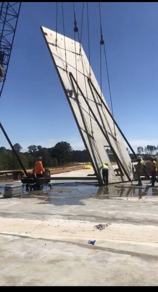 Tilt-up concrete panel being lifted into place by crane