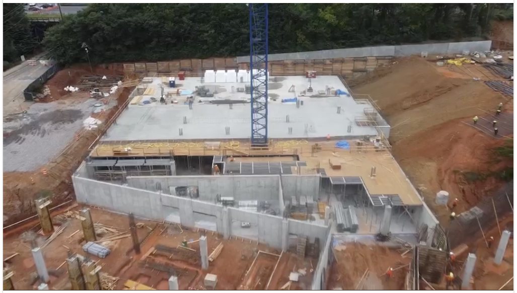 Aerial view of a podium deck pour with tower crane and structural concrete walls