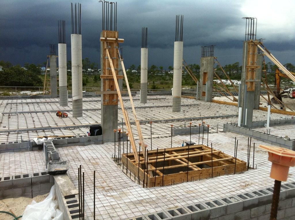 Cast-in-place concrete columns and reinforced slab under a storm sky
