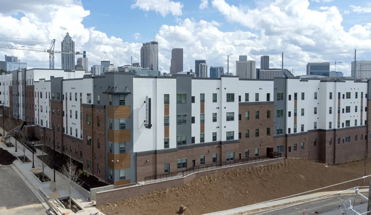 Urban multifamily building with the Atlanta skyline behind it