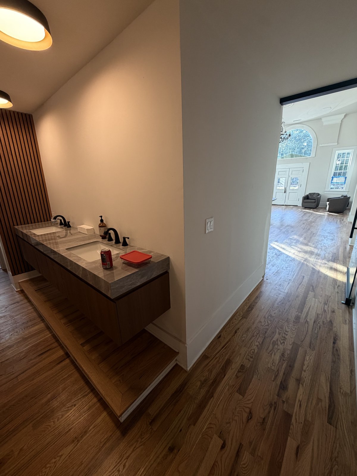 Renovated bathrooms with floating marble vanity and wood slat paneling at the Bank of Buford