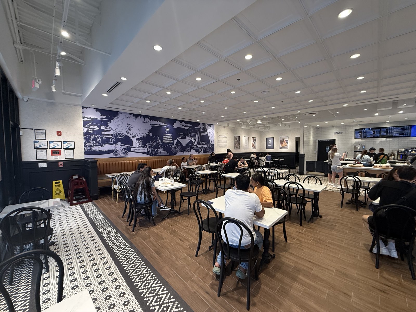 Paris Baguette Kennesaw dining room with custom Kennesaw State mural and banquette seating